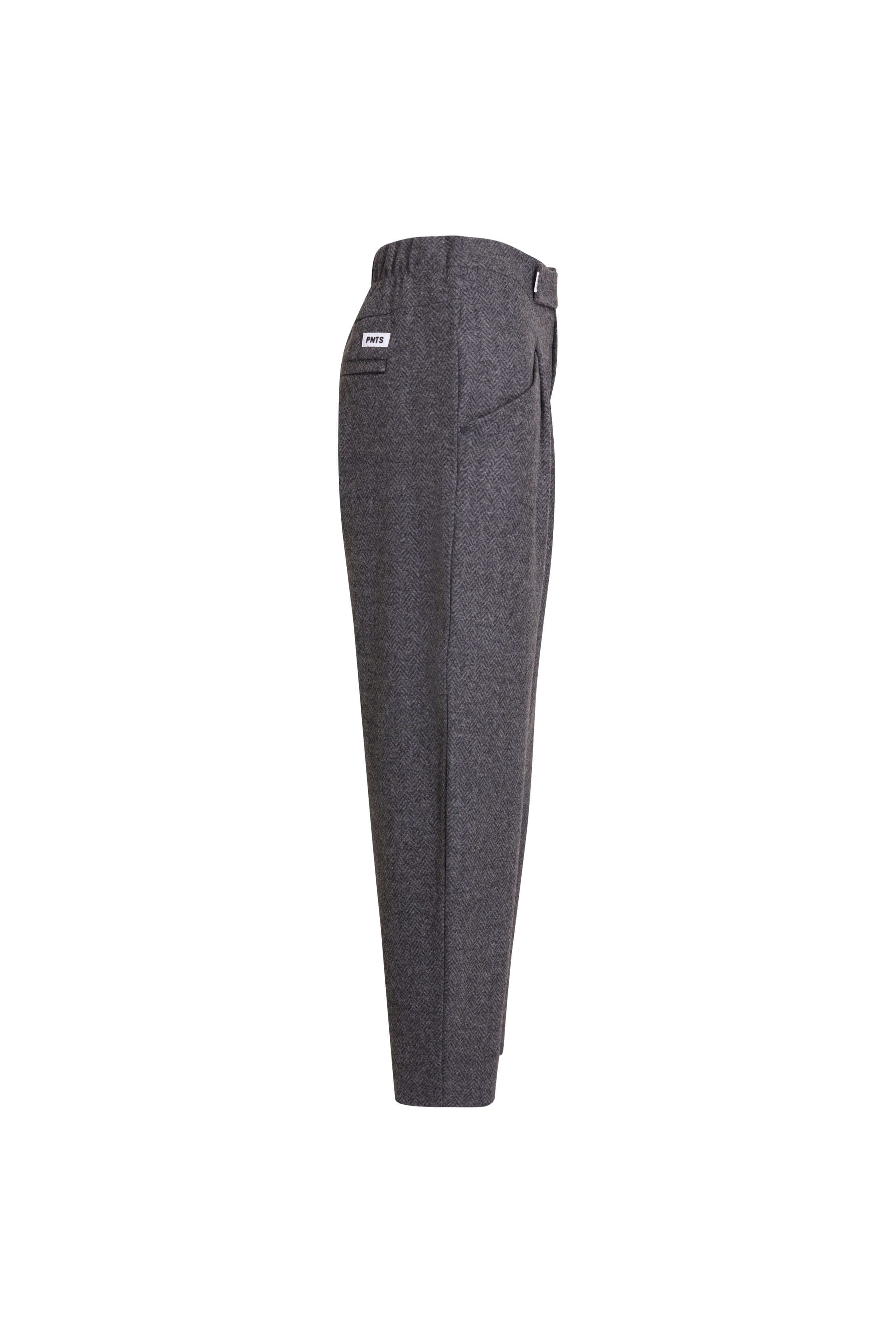 Seitenansicht einer dunkelgrau melierten Hose mit elastischem Bund und weißem Label-Patch am Bund.