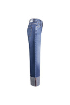 Seitenansicht einer mittelblauen Jeans mit weitem Bein, breitem Aufschlag und weißem Label-Patch am Bund.