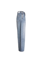Seitenansicht einer hellblauen Jeans mit dekorativer Knopfleiste an der Tasche und weißem Label-Patch am Bund.