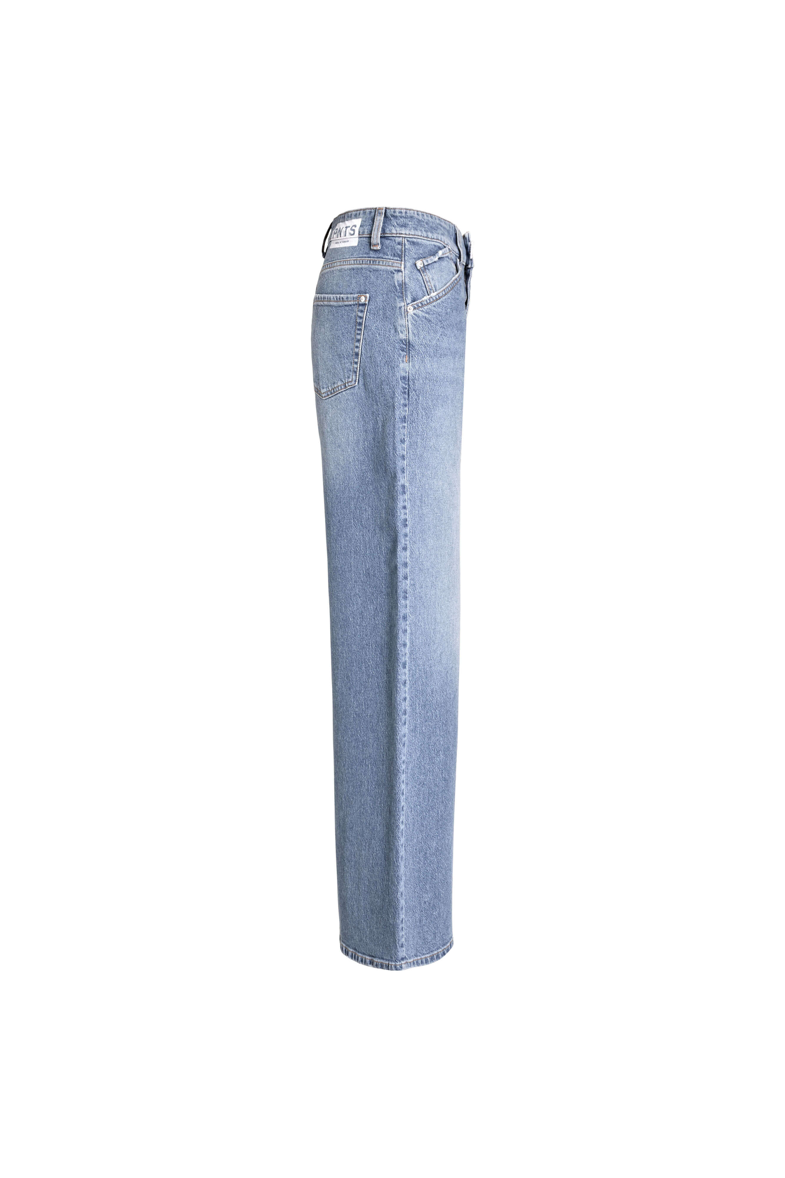 Seitenansicht einer weit geschnittenen Jeans in mittelblauer Waschung mit weißem Label-Patch am Bund.