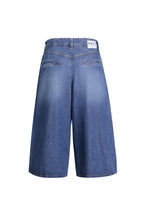 Blaue Denim-Culotte in der Rückansicht mit zwei Paspeltaschen und markantem Logo-Patch am Bund.