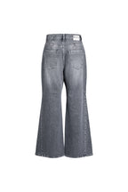 Rückansicht einer grauen Wide-Leg-Jeans mit weißem Label-Patch.