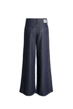 Rückansicht einer dunkelblauen Wide-Leg-Hose mit weißem Label-Patch.