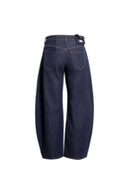 Rückansicht einer dunkelblauen Barrel-Leg-Jeans mit bogenförmigem Beinverlauf.