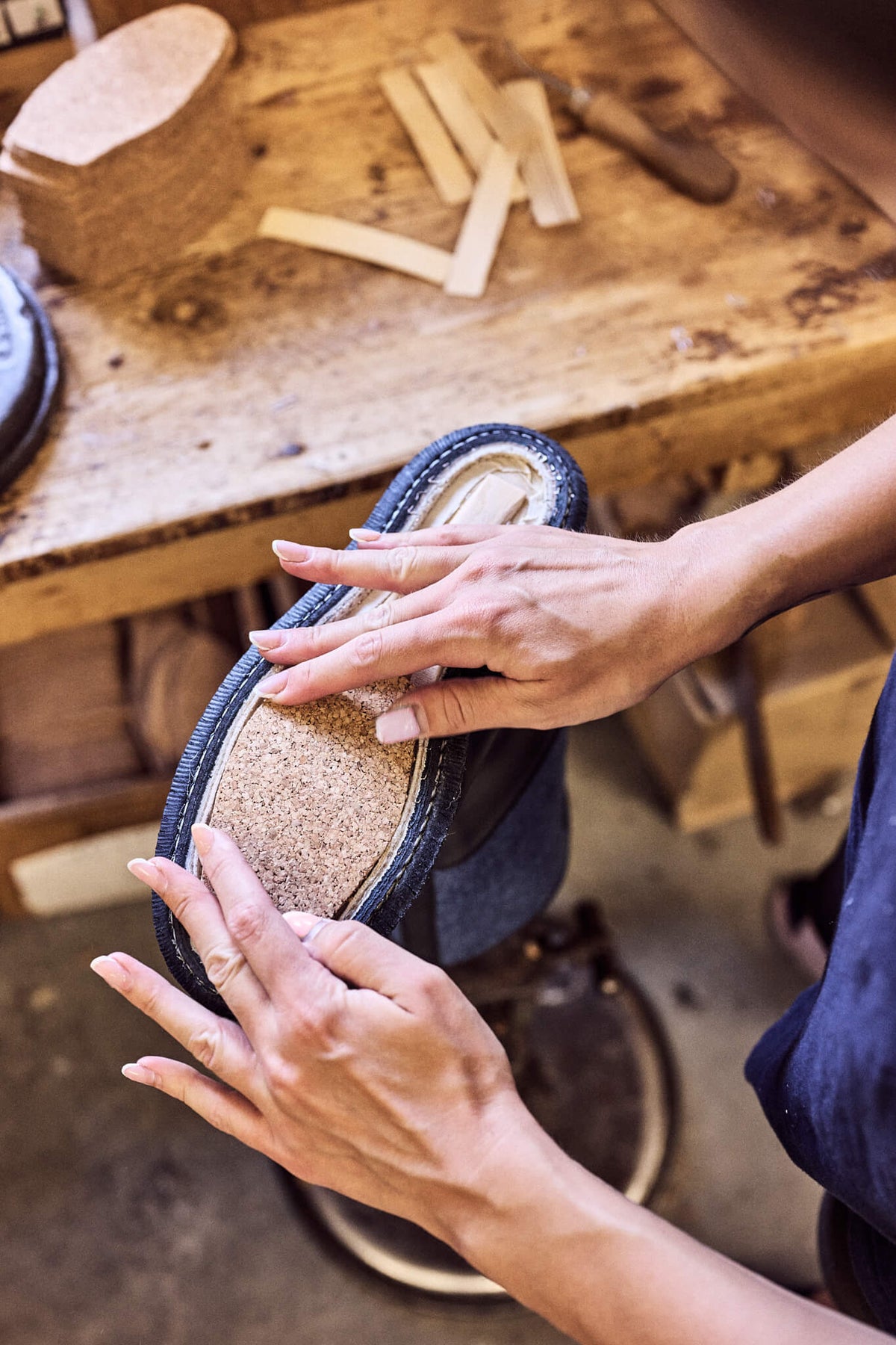 Traditionelle Schuhfertigung: Einsetzen der natürlichen Kork-Ausballung in die Schuhsohle für optimale Dämpfung und Komfort.
