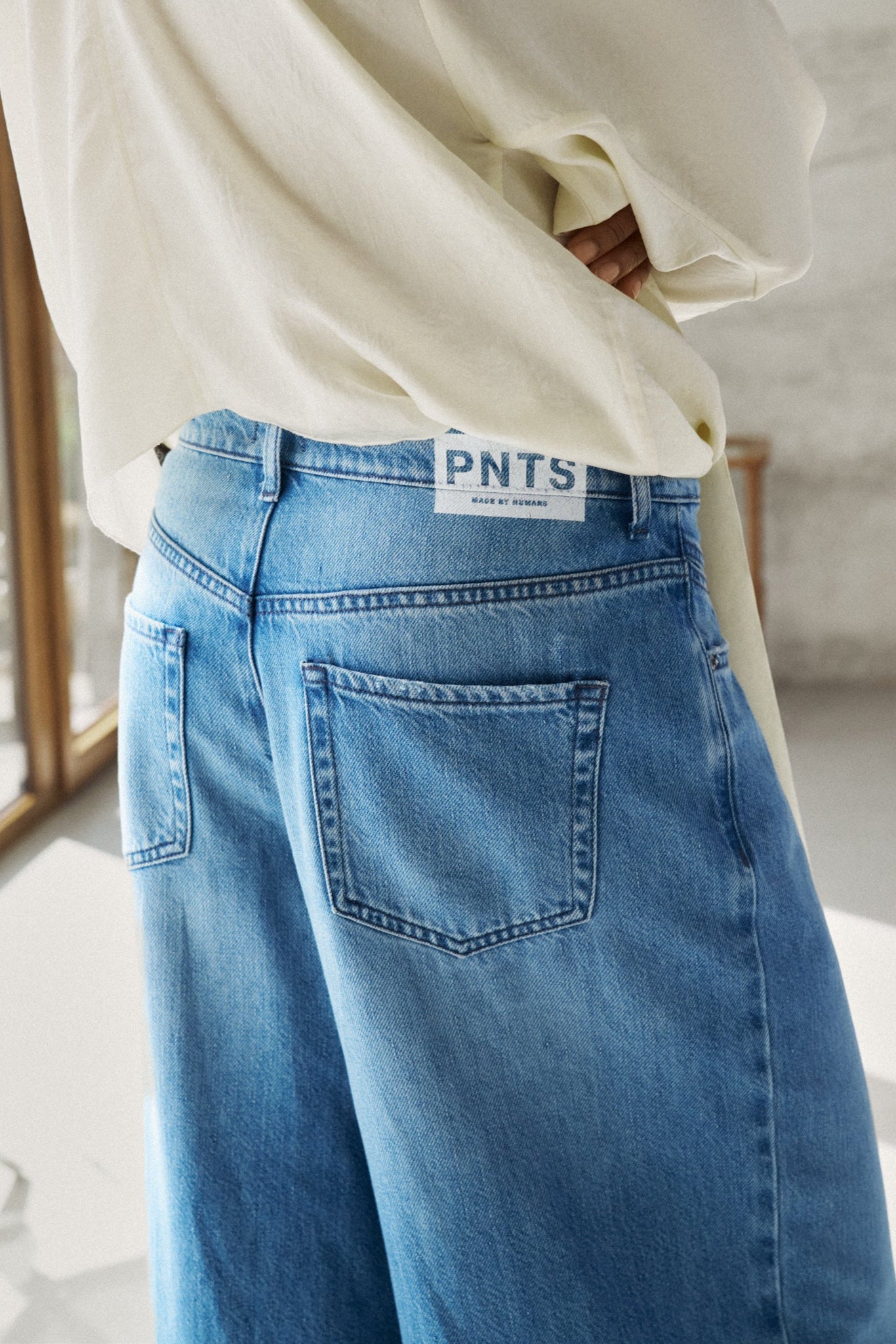 Detailansicht: Man sieht die hinteren Hosentaschen der Jeans 14_THE GENT in hellblau. 