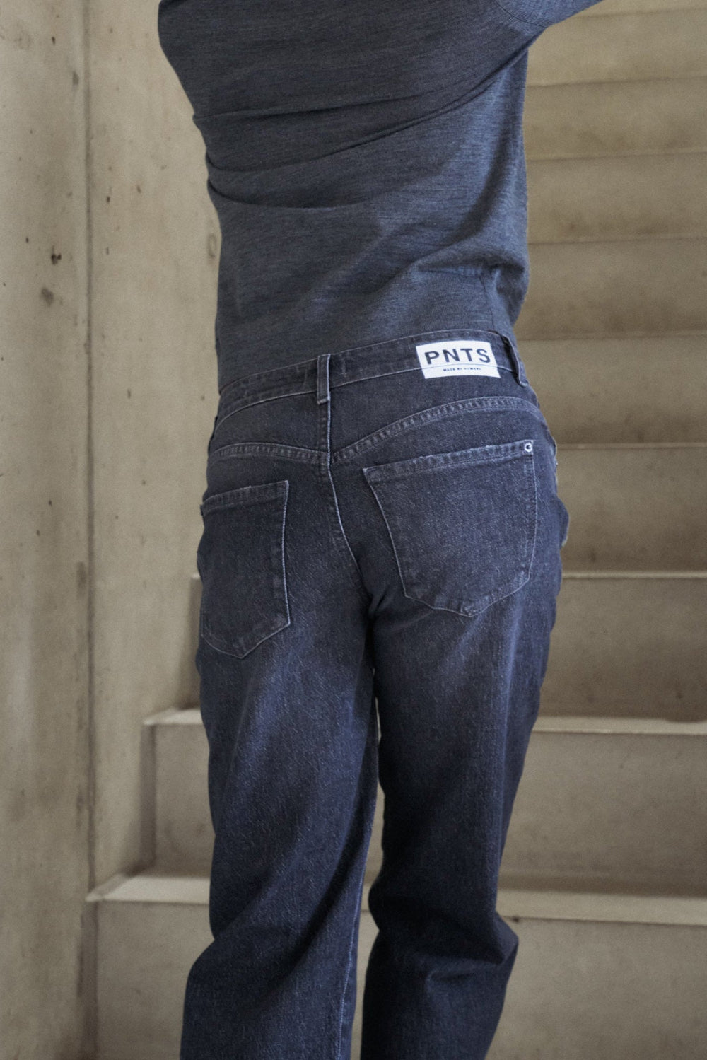 Detailansicht: Man sieht die hinteren Hosentaschen einer Jeans 05_THE O SHAPE in dunkelgrau.