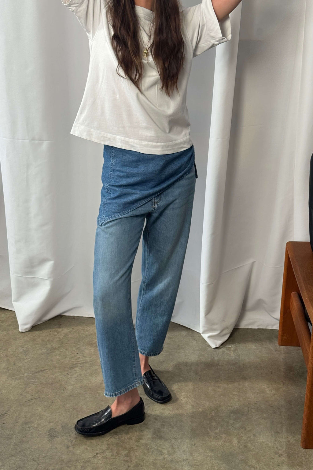 Frau in weißem T-Shirt und blauer Jeans mit einem blauen Denim-Bandana als modischem Hüft-Accessoire.